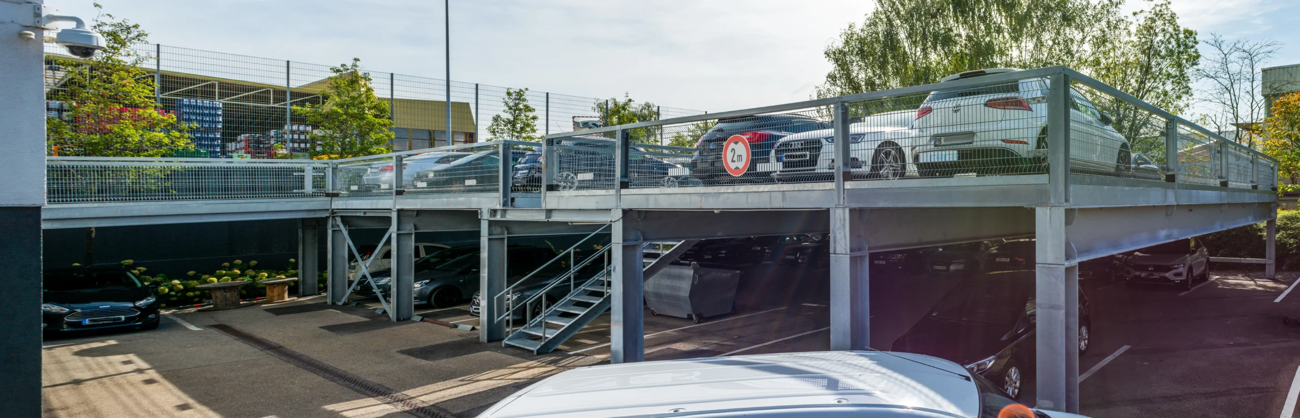 Außenliegende Stahltreppe mit Geländer an einer erhöhten Parkanlage