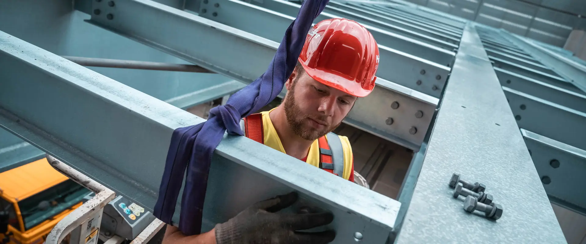 Ein Stahlbaumonteur mit rotem Helm bei der Stahlbaumontage